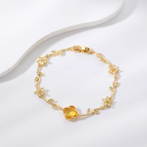 Goldenes Kleeblatt Armband mit gelbem Edelstein auf weißem minimalistischem Display