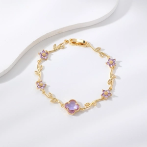 Elegantes Blatt-Armband aus Gold mit lila Zirkon-Blüten und einem Klee-Edelstein