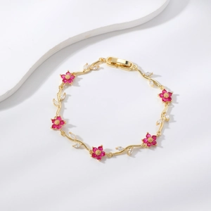 Elegante pulsera de oro con flores de piedras rosas y detalles de hojas de circonita