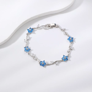 Elegante pulsera de vid plateada con flores de circón azul y detalles de hojas