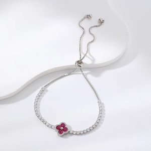 Elegante bracciale tennis a quadrifoglio con pietre rosse e chiusura regolabile su bianco