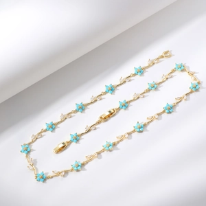 Elegante collana a vite dorata con accenti di fiori blu e foglie di zircone bianco