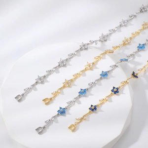 Dettaglio di braccialetti floreali con pietre di zircone e chiusura in metallo a D