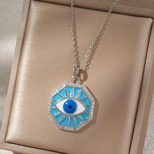 Gros plan du collier pendentif œil maléfique en argent avec émail bleu et zircons