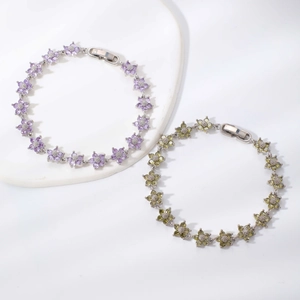 Elegantes silbernes Blumenarmband mit lila und grünen Zirkonia-Kristallen auf Podest