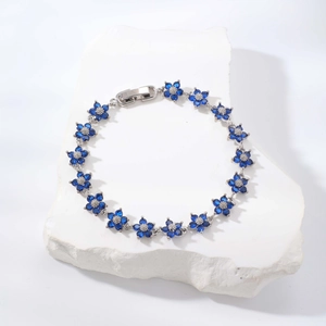 Eleganter Silberblumen-Armband mit blauen Zirkonia auf weißem Steinhintergrund