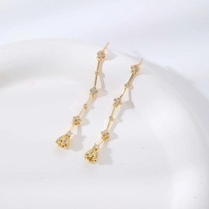 Elegantes pendientes largos de trébol de cuatro hojas dorado con flores de circonita