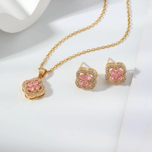 Close-up of gold clover jewelry set with pink stones and sparkling cubic zirconia