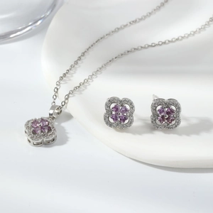Detailed macro view of silver clover jewelry set with purple gemstones and white zircons