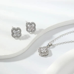 Macro detail of silver four-leaf clover jewelry set featuring sparkling zircon stones