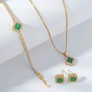 Golden clover jewelry set with green stones including necklace bracelet and earrings