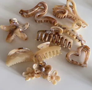 Collection of brown marbled acetate hair claws in flower, star and heart shapes