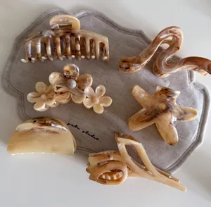 Detailed set of six amber tortoise shell hair claws in flower and star shapes