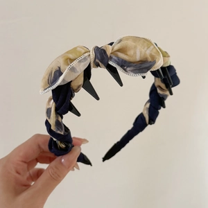 Dettaglio del cerchietto floreale con fiocco e clip integrate per fissare i capelli