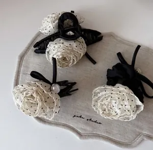 Detail of elegant white polka dot chiffon rose hair claw clip and pearl scrunchies set