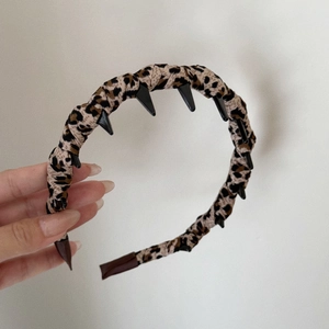 Detailed view of leopard print fabric headband with non-slip black plastic inner teeth