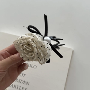 Detail of elegant lace rose hair claw clip with polka dots and faux pearl accent