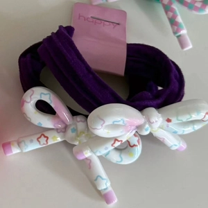 Set of 2 purple floral bow hair ties with star prints on a white background