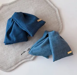 Detail von Denim-Schleifen-Haarklammern mit goldenen Handmade-Schildern in zwei Blautönen
