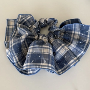 Blue plaid scrunchie with lace trim and heart prints shown at a 45-degree angle