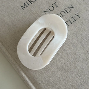 Detail view of cream marble hair claw clip with smooth resin texture and steady teeth