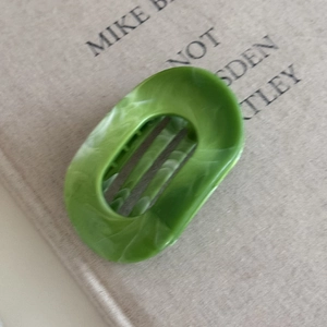 Detail view of the high-quality marble-textured green hair claw clip with internal teeth