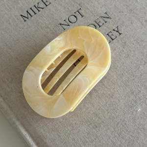 Detailed macro view of cream marble hair claw clip with internal grip teeth structure