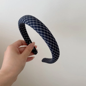 Detailed close-up of blue and white plaid padded headband with hand made inner label