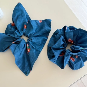 Set of two navy blue floral scrunchies including one with a long bow tie accessory