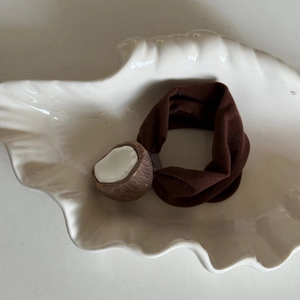 Detail view of a 3D resin coconut charm hair tie placed on a shell ceramic plate