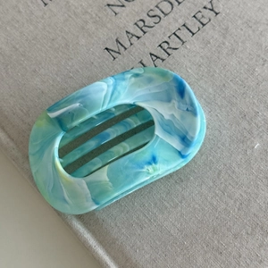 Detail view of oval blue marble flat hair claw clip made of high-quality ABS material
