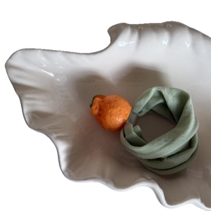 Cute mandarin orange elastic hair tie with light green scrunchie fabric in shell tray