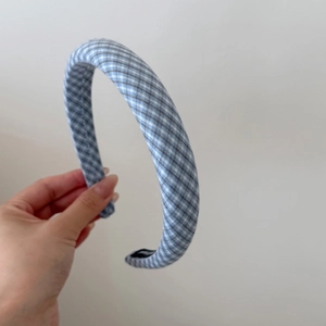Close-up of blue and white checkered padded headband with black anti-slip inner lining