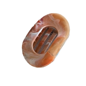 Flat oval hair claw clip with orange and white marble pattern made of durable ABS