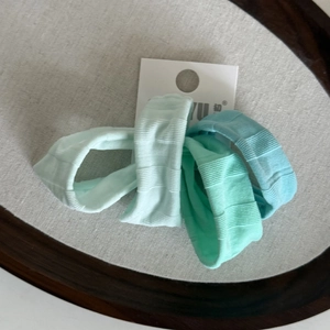 Lot de quatre chouchous en soie nervurée élastique aux tons vert menthe et bleu sur carte