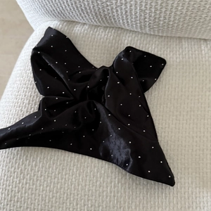 Close-up of black satin square scarf featuring sparkling silver rhinestones on fabric