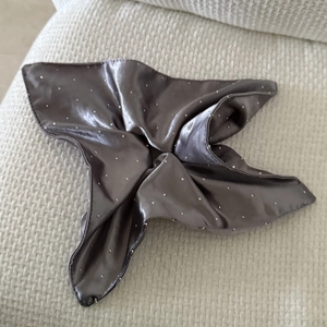 Deep grey satin hair scrunchie with rhinestones on a white textured background