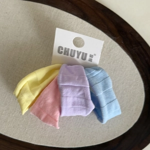Détail de quatre élastiques à cheveux en soie glacée colorée avec étiquette de marque