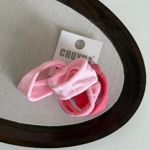 Vue détaillée des chouchous roses avec texture côtelée et étiquette de marque sur plateau