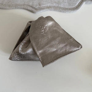 Detailed view of grey satin fabric featuring embossed 3D rose floral texture and glossy finish