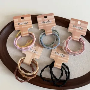 Detail view of colorful high-elasticity bamboo joint hair ties on a premium display card