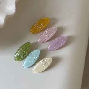 Detailed view of six colorful glitter resin oval hair clips in fresh pastel colors