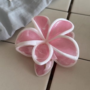 Dettaglio del fermaglio per capelli in acetato con motivo marmorizzato rosa e fiori