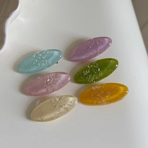 Set of six colorful translucent oval hair clips with sparkling glitter and shell inlay