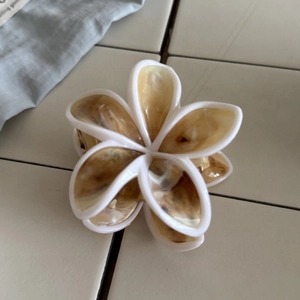 Elegante pinza per capelli a fiore di frangipane con acetato ambrato e bordo bianco
