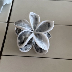 Dettaglio della molletta per capelli a fiore con trama marmorizzata in bianco e nero