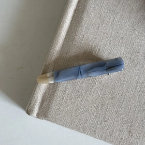 Detail of blue acetate hair clip with marble texture and handmade engraving