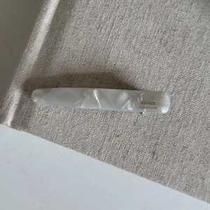 Detail of handmade marble pattern acetate hair clip with gold France lettering