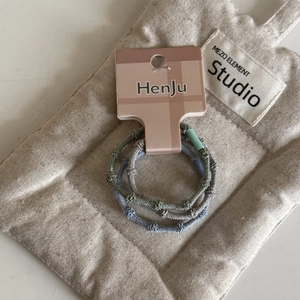 Close-up of three elastic candy-colored hair ties on a premium branded display card