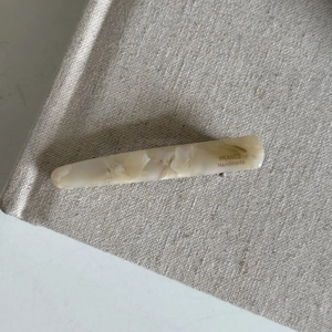 Detailed close-up of cream marble textured acetate hair clip with France Handmade text
